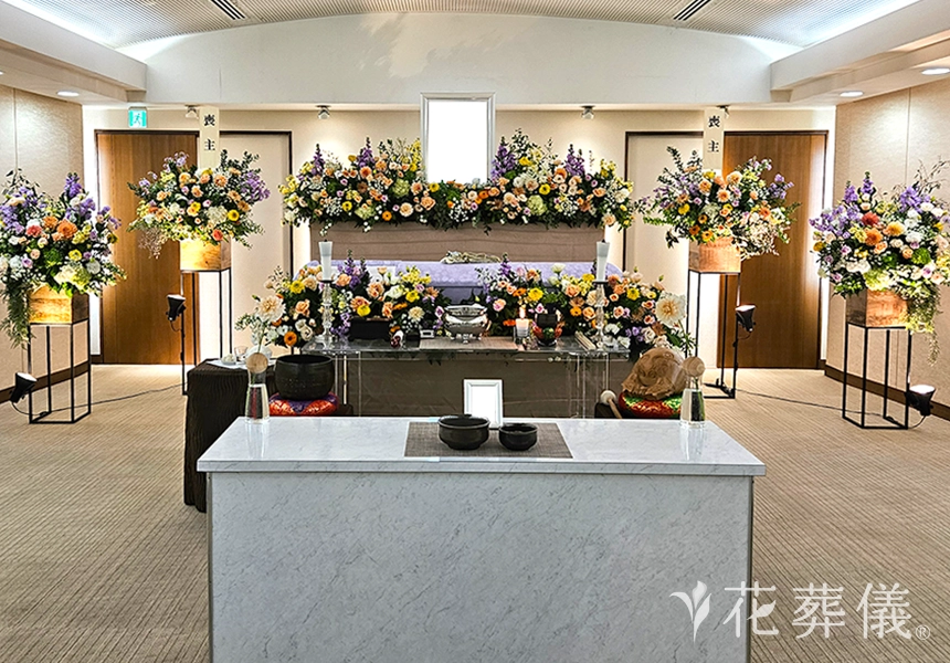 花祭壇のデザイン　暖色系でお飾りし、元気でカラフルな明るい空間で送り出すイメージの花祭壇